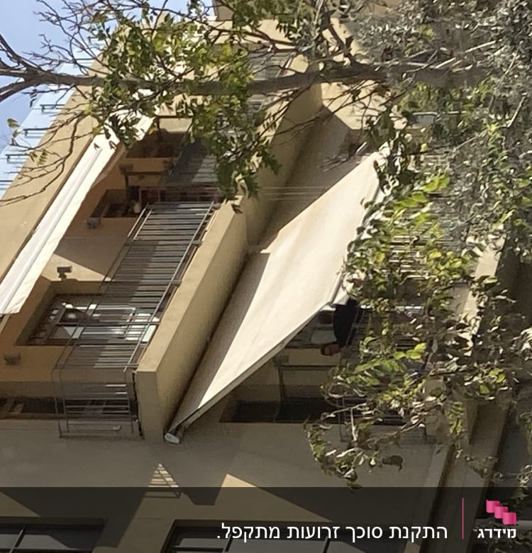 שני סוככים לבנים על מרפסת בניין